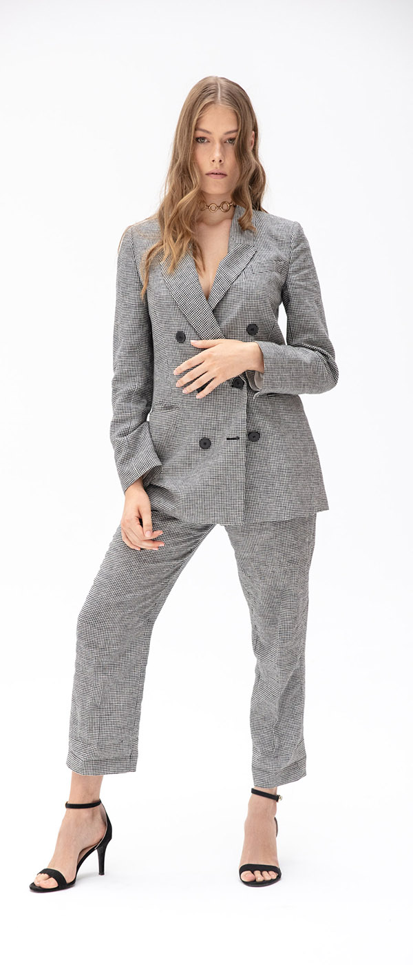Female model in grey suit against white background